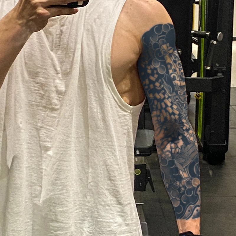 Person taking a selfie with a tattooed arm in a gym setting