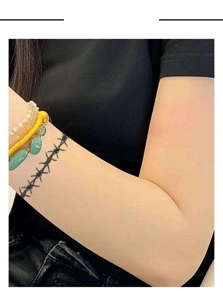 Barbed wire tattoo on a person's arm with a black background