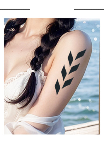 Woman with black leaf tattoo on arm by water