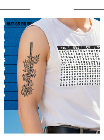 Person wearing a white sleeveless shirt with a black text pattern, displaying a tattoo on their arm.