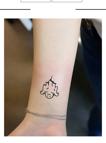 Small black tattoo on a person's wrist with a blurred background
